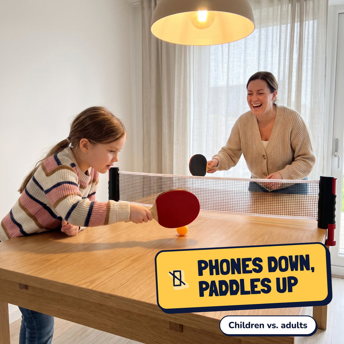 Daughter and mom play ping-pong across the net on the table. Phones down, paddles up, children vs. adults
