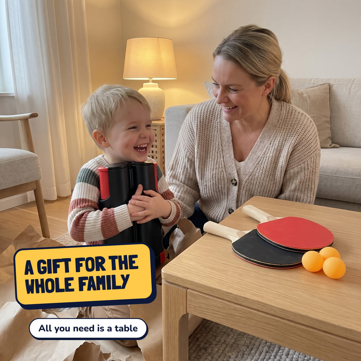 A child hugs the ping-pong net among wrapping paper with mom beside them. A gift for the whole family