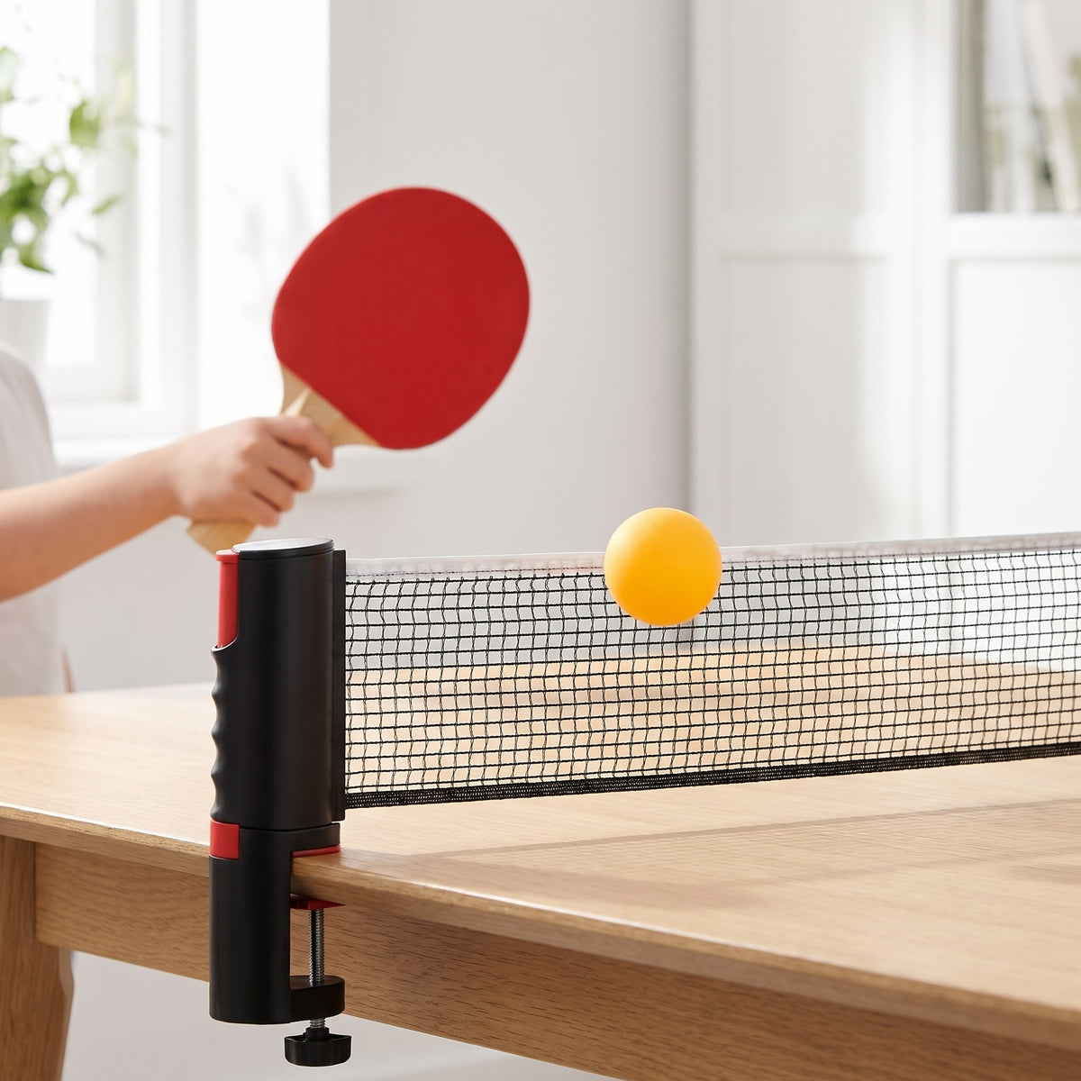 Yellow ping-pong ball in the air above the net on the dining table